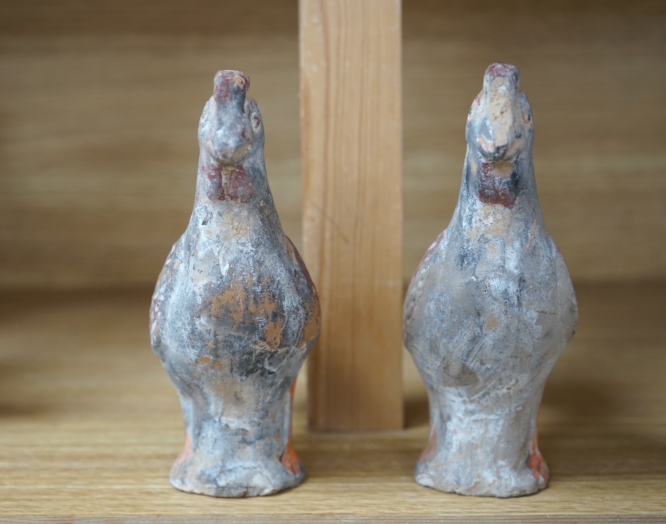 A pair of Chinese pottery figures of cockerels, Han Dynasty or later, height 17cm. Condition - fair